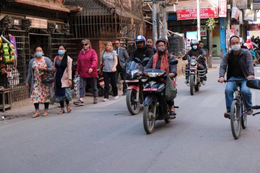 Katmandu Nepal Asya 'daki thamel sokak pazarında Covid-19' dan korunmak için koruyucu maskeler takan insanlar.