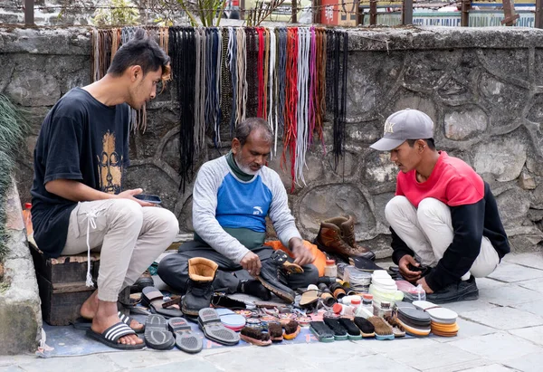 Man fastställande och rengöring skor på gatorna i Pokhara, Nepal Asien. Arbete på gatan. — Stockfoto
