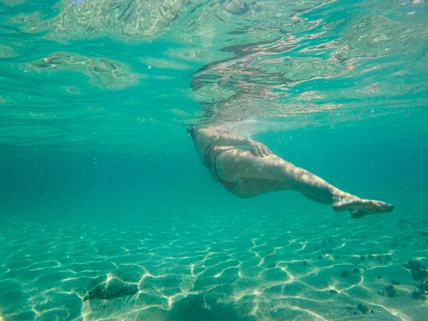 Junge unerkannte Frau mit Badebekleidung schwimmt unter Wasser. — Stockfoto