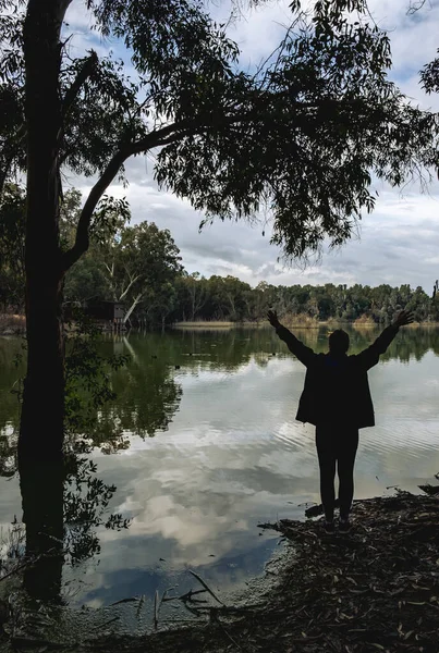 Pessoa não reconhecida de pé e desfrutando da paisagem em um lago. — Fotografia de Stock