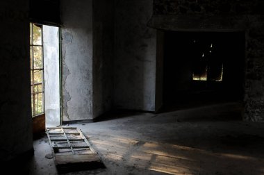 Terk edilmiş oda kırık kapı ve dramatik parlak güneş ışığı içeri giriyor.