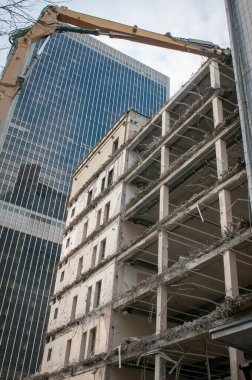 Sürüngen kazıcı eski bir otelin yıkımında çalışıyor. İnşaat tarafında kazıcı.