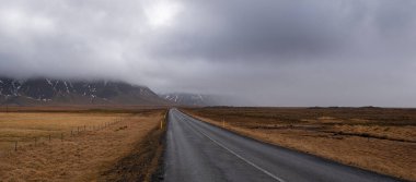 İzlanda 'nın baharında boş bir kırsal yol. Fırtınalı İzlanda manzarası