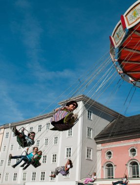 İnsanlar dönme dolapta dönüp eğleniyorlar.