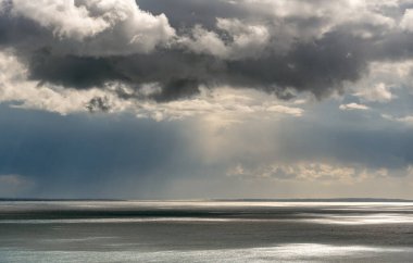 Fırtınalı gökyüzü, dramatik bulutlar ve deniz. Okyanusta fırtınalı bir hava