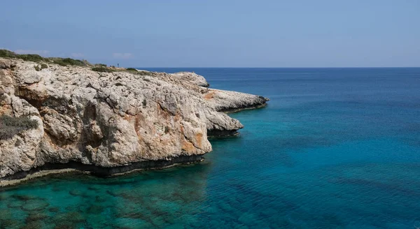 Costa rocosa con agua azul y cielo. — Foto de Stock