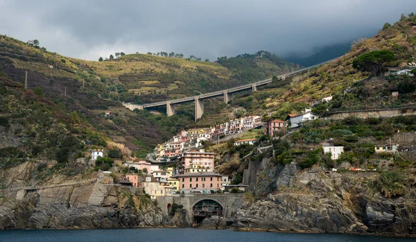 Ciudad de Riomaggiore en el borde de un acantilado rocoso, Cinque Terre Liguria, Italia —  Fotos de Stock