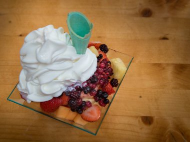 Sağlıklı meyve salatası, garnitür ve tabakta dondurma.