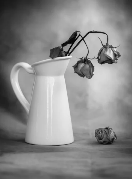 Flores de rosas secas murchas em um vaso branco e fundo vintage — Fotografia de Stock