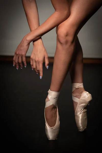 검은 바닥 배경에서 춤을 추고 있는 젊은 발레리나의 다리. 발레 연습. 발레 무용수 의발. — 스톡 사진