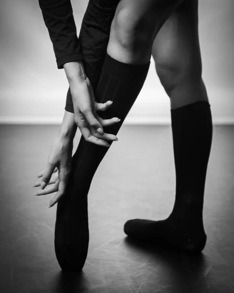 검은 바닥 배경에서 춤을 추고 있는 젊은 발레리나의 다리. 발레 연습. 발레 무용수 의발. — 스톡 사진