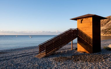 Güneş doğarken cankurtaran ahşap kulesi. Boş sahil Kıbrıs Rum Kesimi