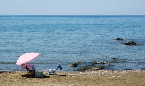 Beach umbrella and relaxing chair on a sandy coast in summer. Summertime holidays — Stock Photo, Image