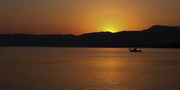 Łodzi rybackiej pływających w morzu do połowu ryb o wschodzie słońca. — Zdjęcie stockowe