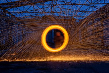 Turuncu daire siyah zemin üzerinde ışık ateş izlerini hareket ettiriyor.