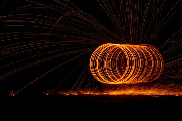 黒の背景にオレンジ色の円が光火の道を動かす. — ストック写真