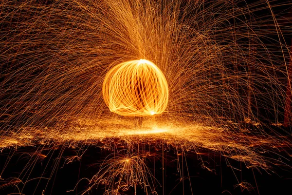 黒の背景にオレンジ色の円が光火の道を動かす. — ストック写真
