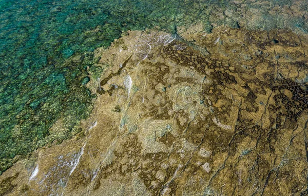 Zicht vanuit de lucht op doorzichtig zeewater met rotsen op de bodem. Oceaanachtergrond — Stockfoto