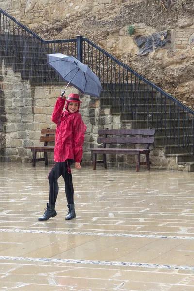 Giovane donna felice con un ombrello che balla sotto la pioggia . — Foto Stock