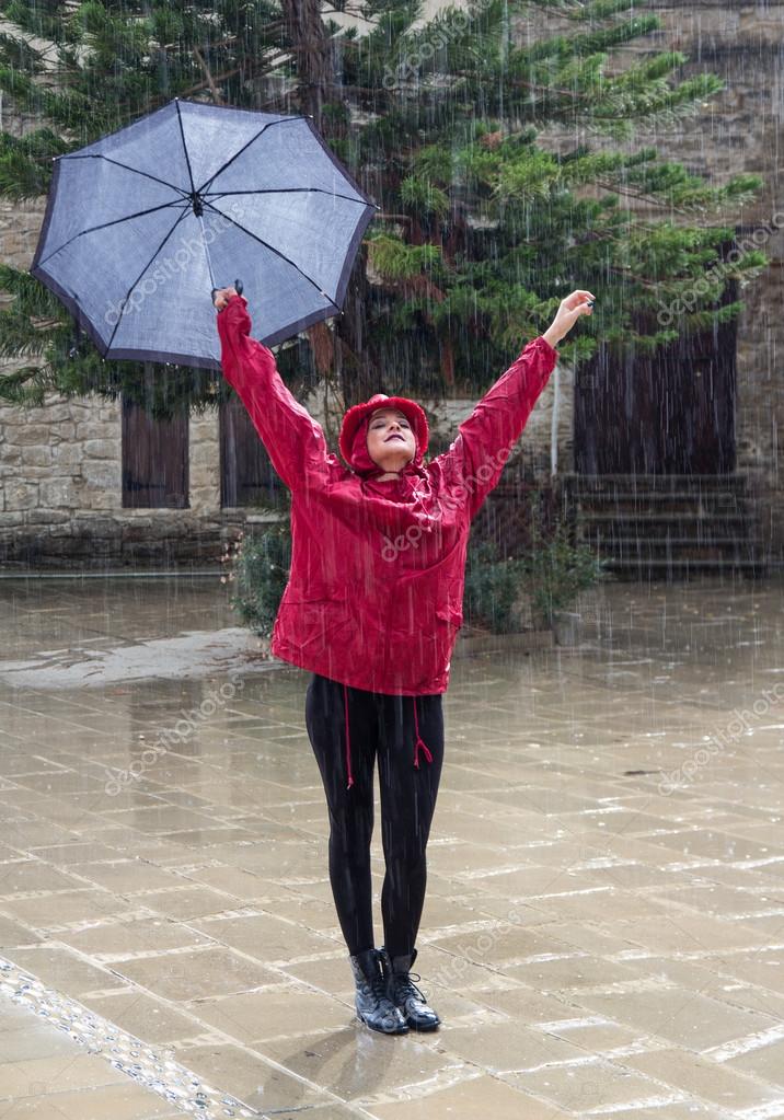 Young Happy Woman With An Umbrella Dancing In The Rain Stock