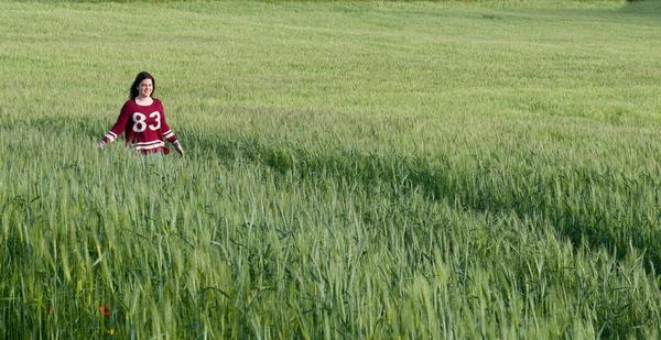 Jovem adolescente caminhando em um campo de trigo — Fotografia de Stock