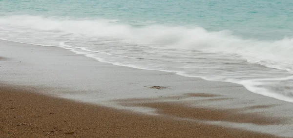 Kust golven met zandstrand achtergrond — Stockfoto