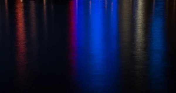 Sfondo acqua colorato dalle luci della città — Foto Stock