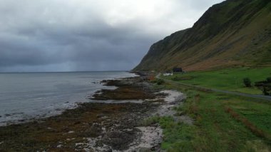  Hava aracı fırtınalı okyanus dalgalarının çakıl taşlı bir kıyıya vuruşunu gösteriyor. Lofoten Adaları Norveç. Ultra Yüksek Tanımlama