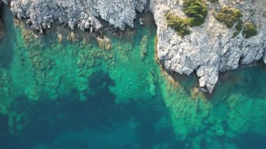 Turkuaz suların engebeli kayalık kıyılarla buluşması çarpıcı bir manzara yaratır. Doğadaki bu güzel kıyı bölgesi canlı deniz yaşamını ve el değmemiş çevreyi sergiliyor. İnsansız hava aracı kayalık kıyısı
