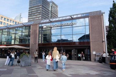 Oslo, Hollanda, 8 Ağustos 2025: Norveç 'te popüler bir ulaşım merkezi olan Oslo merkez sentralstasjon istasyonunun önünde yürüyen insanlar