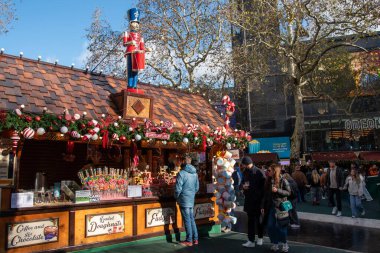 Londra, Birleşik Krallık, 23 Kasım 2025: Meşgul bir Leicester Meydanı Londra Noel Pazarı 'ndaki şekerleme tezgahında fındıkkıran figürü