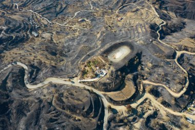 Kavrulmuş zemin, gün ışığında kömürleşmiş ağaçlar ve karartılmış topraklar bırakarak ormanı kasıp kavuran yıkıcı bir yangının sonuçlarını gösteriyor. Kıbrıs Rum Kesimi