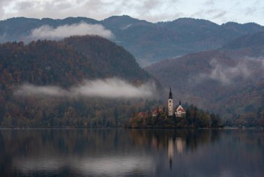 Mary Hac Kilisesi 'nin sakin gölü yansıttığı varsayımı kanıyordu. Dağlar ve renkli sonbahar yapraklarıyla çevrelenmişti.