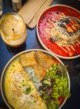 Lezzetli bir omlet, krep ve ferahlatıcı buzlu kahveyle nefis bir brunch manzarası.