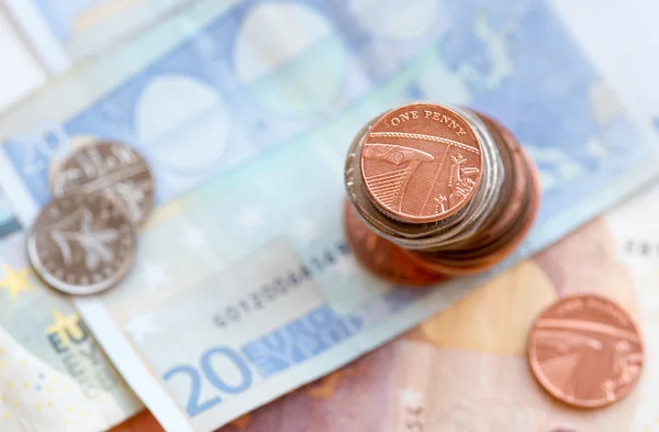 Une pièce de un penny britannique et des billets en euros — Photo