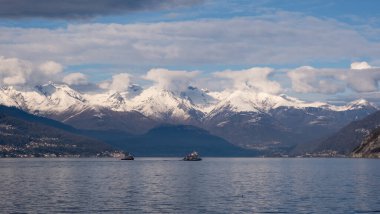 İtalya 'da göl komosunu gezen iki feribot. Kıyıdaki köyler ve uzaktaki Alp dağlarının görkemli karları ile kaplı.