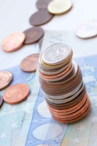 Monedas en una pila y billetes de euros —  Fotos de Stock