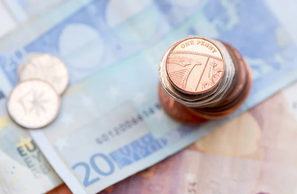 Britse een cent munt en 20 eurobiljet — Stockfoto