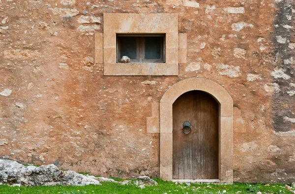 Pencere ve kapı ile taştan bir duvar ayrıntılarını — Stok fotoğraf