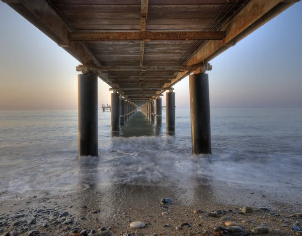 Roestige metalen pier van zeeniveau — Stockfoto