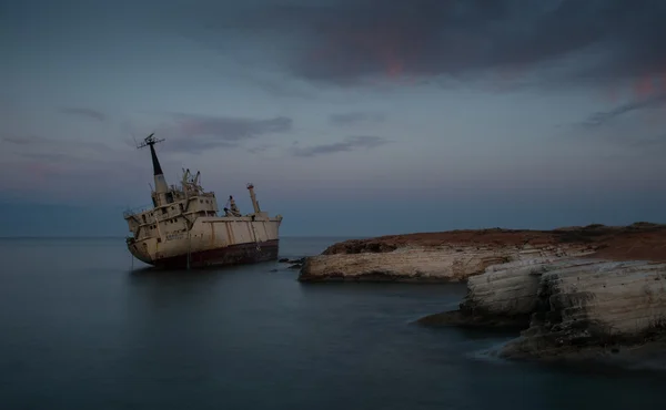 Barco abandonado en una costa rocosa Imágenes de stock libres de derechos