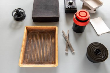Geleneksel karanlık oda fotoğraf geliştirmede kullanılan tepsiler, film makaraları, gelişmekte olan bir tank ve aksesuarlar gibi analog fotoğrafçılık araçları.