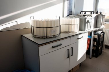 Laboratuvar tezgahına konmuş otomatik bir atık su örnekleyicisi için aksesuarlar ve kaplar, çevresel testler için su örneklerini toplamak ve depolamak için kullanılır..