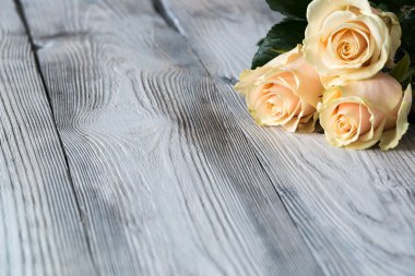 Eski gri kırık ahşap zemin ile üç çiçek