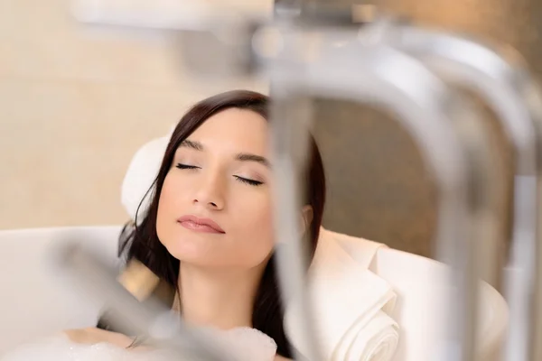 Brunette relaxante no banho com espuma. Olhos fechados — Fotografia de Stock