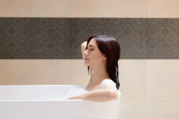 Beautiful brunette woman relaxing in bathtub — Stock Photo, Image