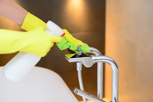 Mains avec gants de protection en caoutchouc jaune nettoyant mélangeur de bain — Photo