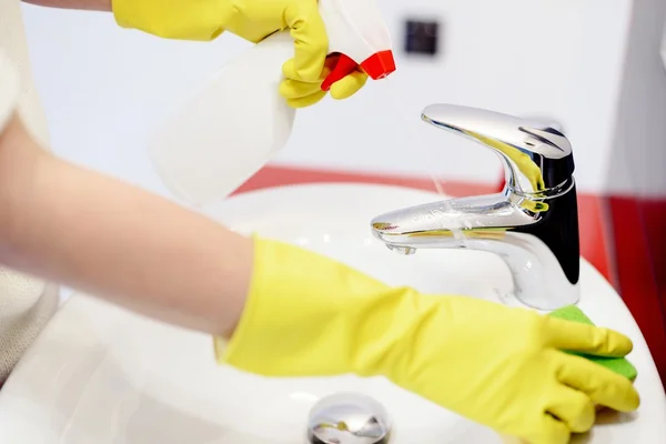 Mani femminili spruzzando detersivo liquido al rubinetto — Foto Stock