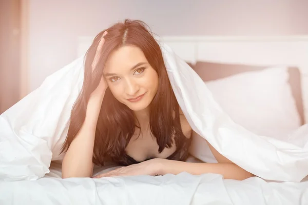 Junge schöne brünette Frau schaut aus Decke — Stockfoto