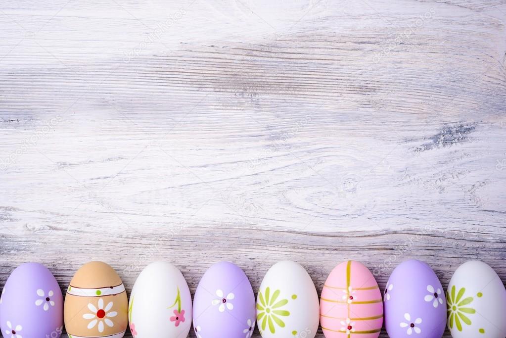 Pastel colors Easter eggs on a grey wooden background. Stock Photo by